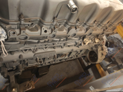 A close-up of a metallic engine block or mechanical component with visible bolts, ports, and internal structure, photographed in a workshop setting. Repeated 'EURO TRUCK PARTS' watermarks are visible across the image.